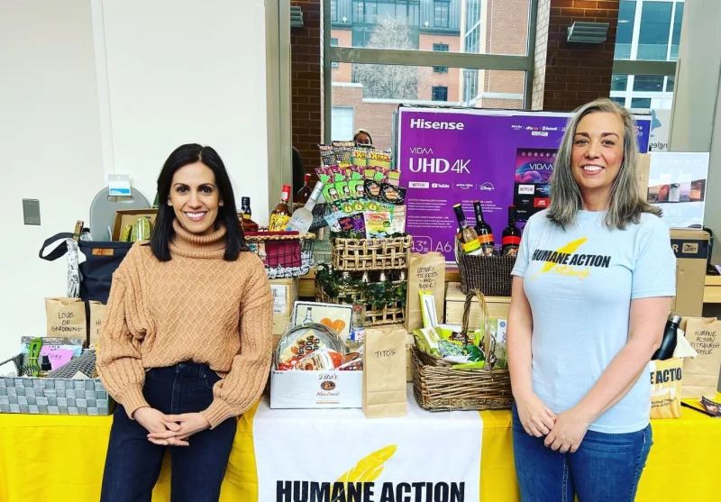 Humane Action Pennsylvania team members standing with a table full of gifts at a fundraising event.
