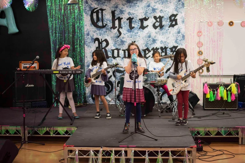 A group of young musicians performing as part of a Chicxs Rockerxs event.
